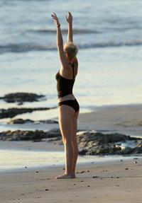 Miley Cyrus  yoga in black bikini on beach in Hawaii 1/24/13 