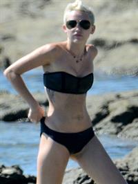 Miley Cyrus  yoga in black bikini on beach in Hawaii 1/24/13 
