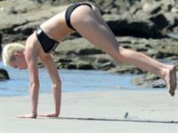Miley Cyrus  yoga in black bikini on beach in Hawaii 1/24/13 