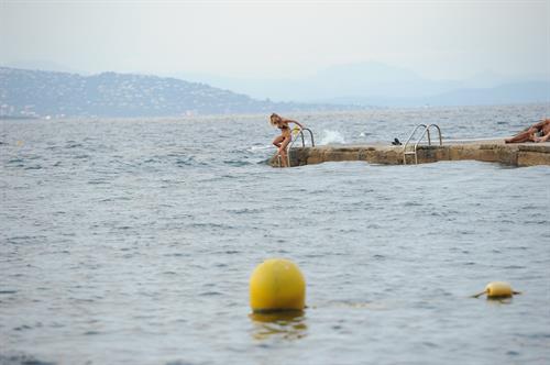 Kimberley Garner in a black bikini on the beach in St. Tropez on July 31, 2014