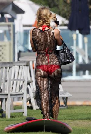 Paris Hilton at the beach in a skimpy red bikini and fishnet kaftan in Malibu.July 12, 2013