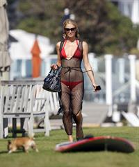 Paris Hilton at the beach in a skimpy red bikini and fishnet kaftan in Malibu.July 12, 2013