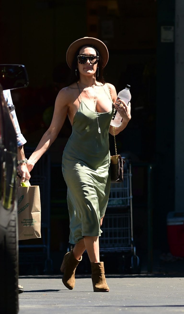 Nikki Bella Pictures Nikki Bella braless boobs in a green dress seen by paparazzi.