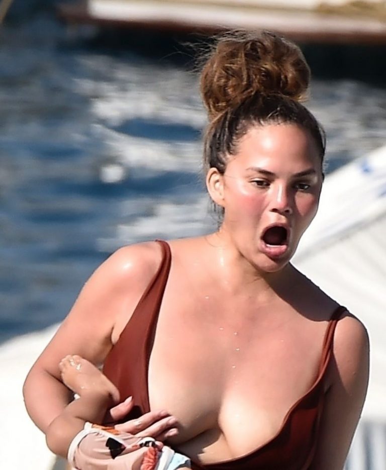 Chrissy Teigen Pictures Chrissy Teigen sexy cleavage and ass in a swimsuit with her husband John Legend seen by paparazzi.