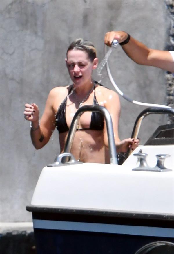 Kristen Stewart nude boobs caught topless by paparazzi tanning on a boat.
