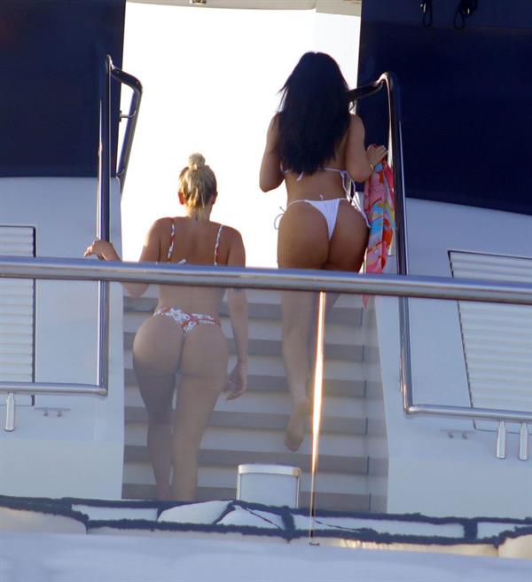 Kylie Jenner sexy ass in a thong bikini also showing nice cleavage seen by paparazzi on her super yacht.
