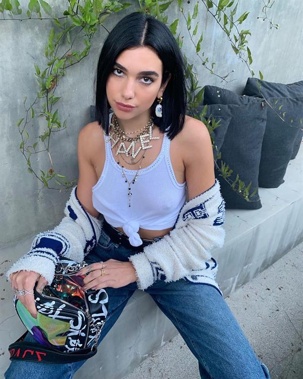 Dua Lipa braless tits in a see through white top showing her boobs.







