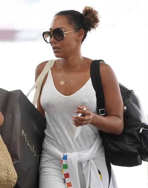 Melanie Brown Pictures Mel B braless boobs in a see through white top showing off her tits seen by paparazzi at the airport.