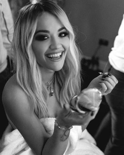 Rita Ora nude in just a robe backstage showing some nice cleavage.


