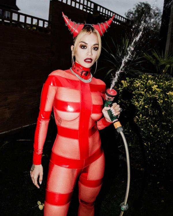 Rita Ora braless boobs in a see through costume showing off her big tits also going pantyless dressed as a devil.