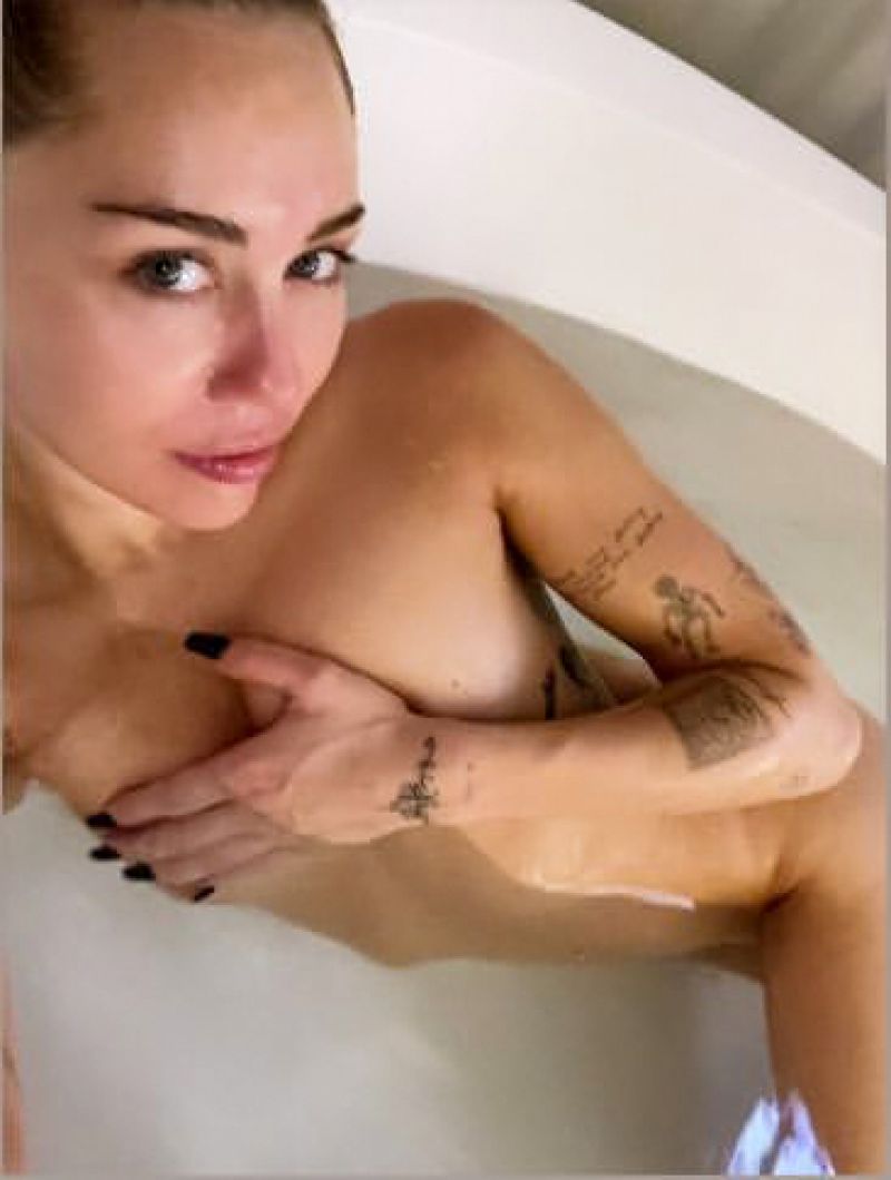 Miley Cyrus Boobs Porn - Miley Cyrus nude new photo posing naked in her bathtub holding her topless  boobs barely covering her pussy. Rating = 7.74/10