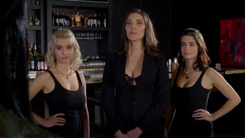 Julia Bertin wearing black lingerie underneath a black coat, alongside Lauren Burch and Julia Burch.