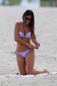 Claudia Romani in a purple thong bikini at the beach